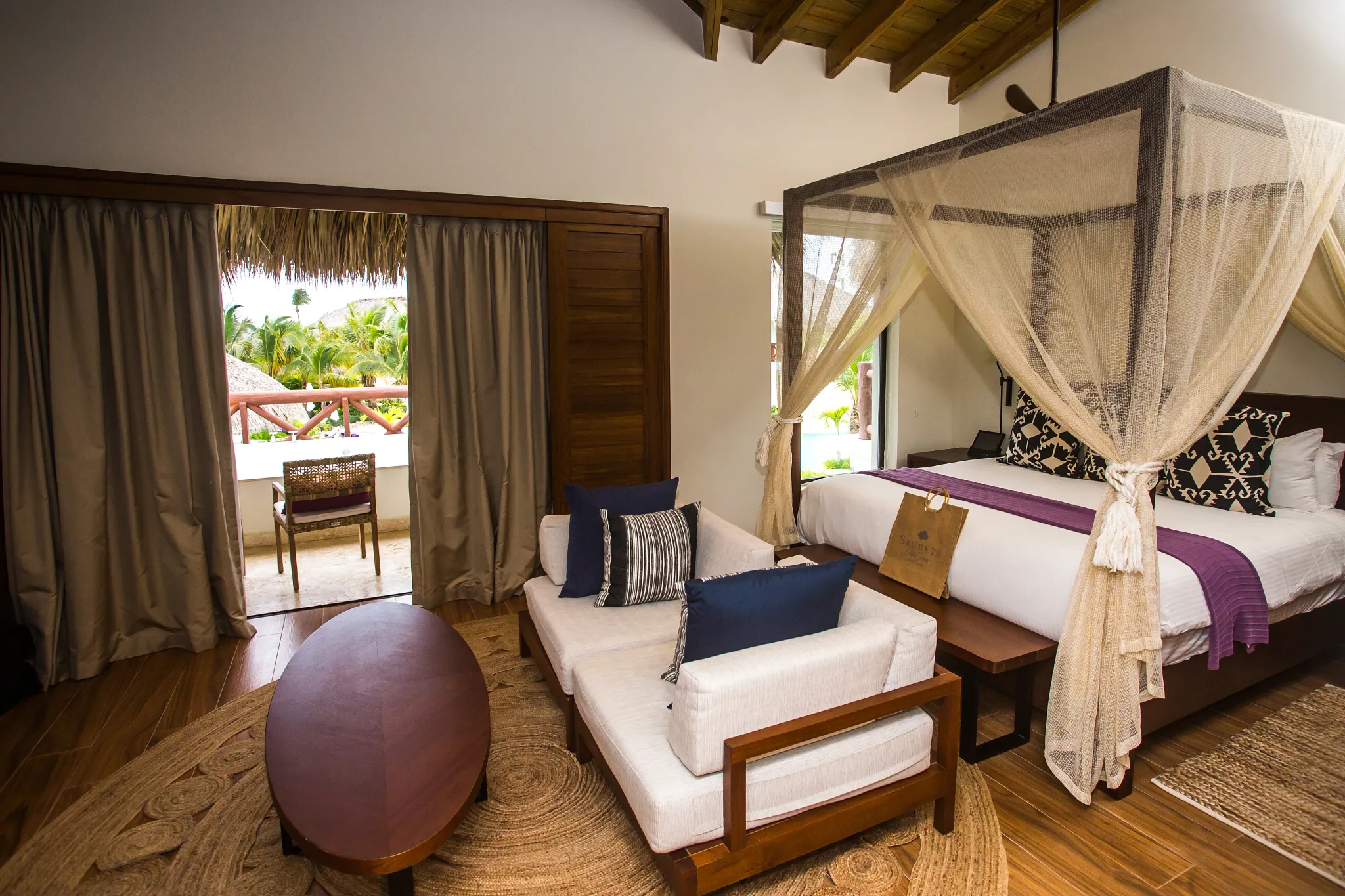 Preferred Club Bungalow Master Suite Pool View with king-size canopy bed, sitting area, furnished balcony, and luxury Caribbean décor.