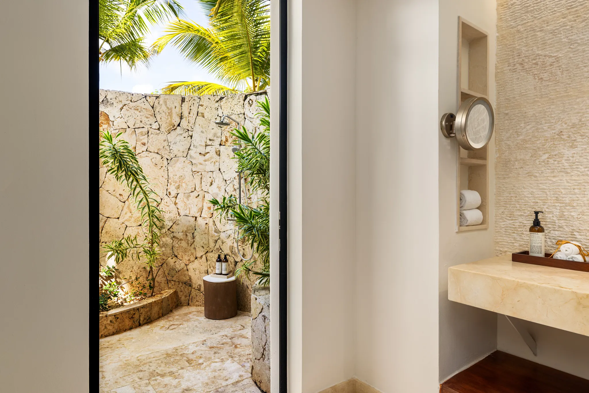 Preferred Club Bungalow Suite Swim Out Ocean Front bathroom with illuminated mirror, double vanity, and upscale natural stone finishes.