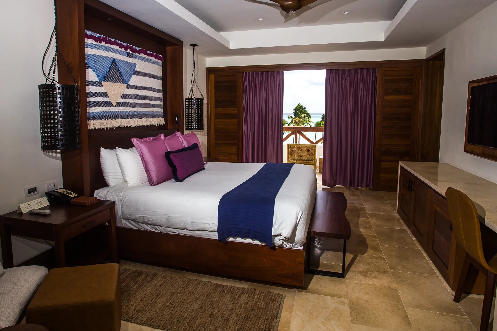 Preferred Club Master Suite Ocean Front bedroom with king-size bed, ocean-view balcony, and upscale tropical décor.