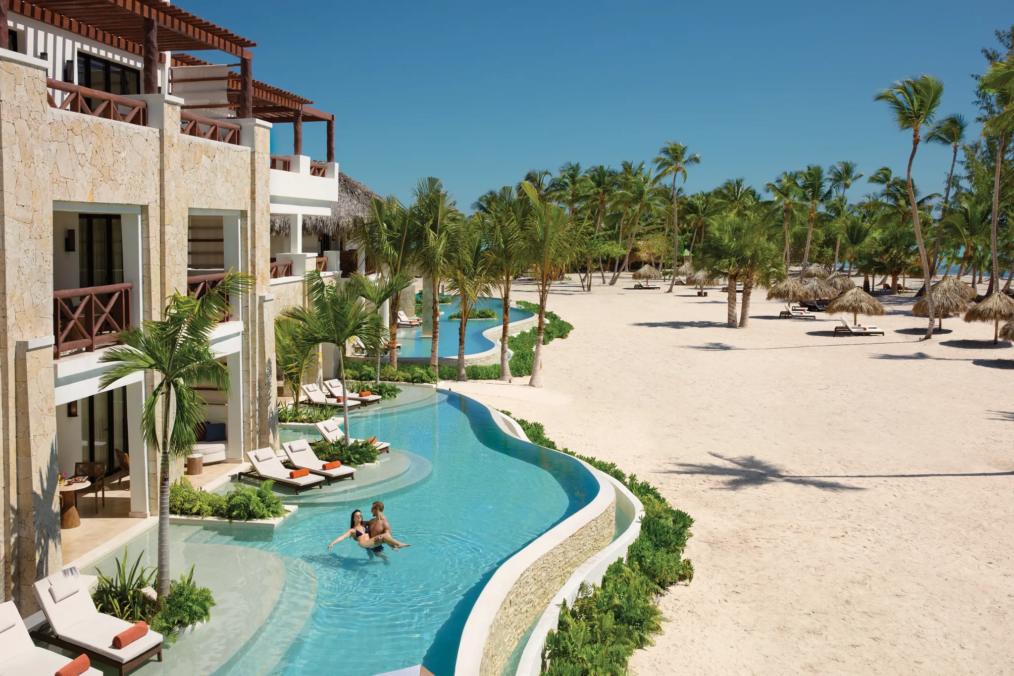 Oceanfront swim-out suites with direct pool access, tropical landscaping, and white-sand beach views at Secrets Cap Cana.