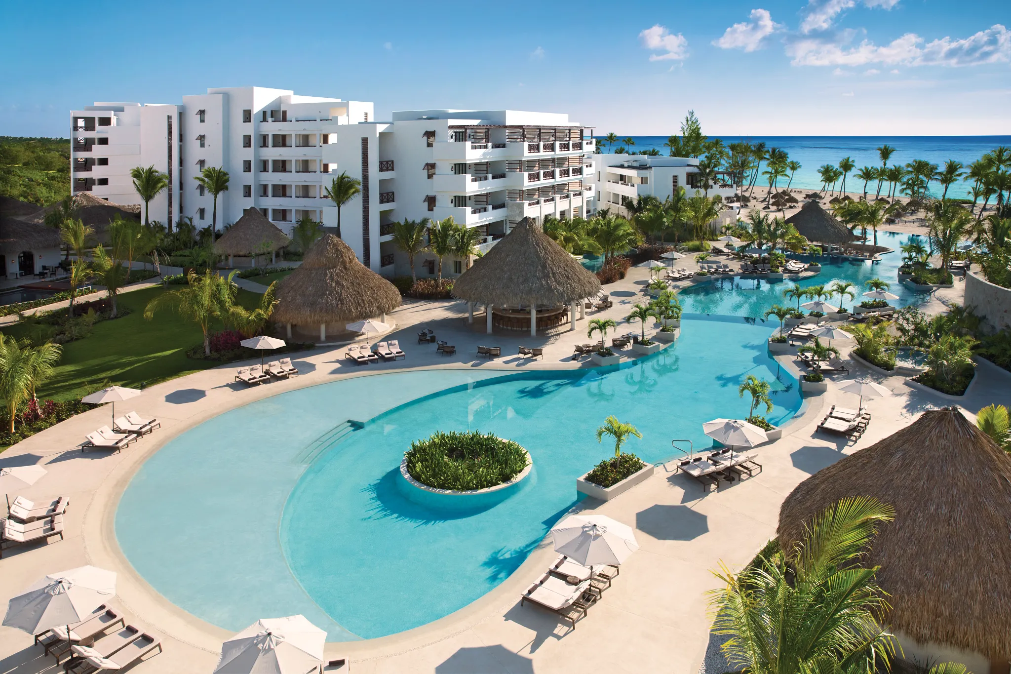 Expansive resort pool surrounded by tropical landscaping and luxury accommodations at Secrets Cap Cana Resort & Spa.